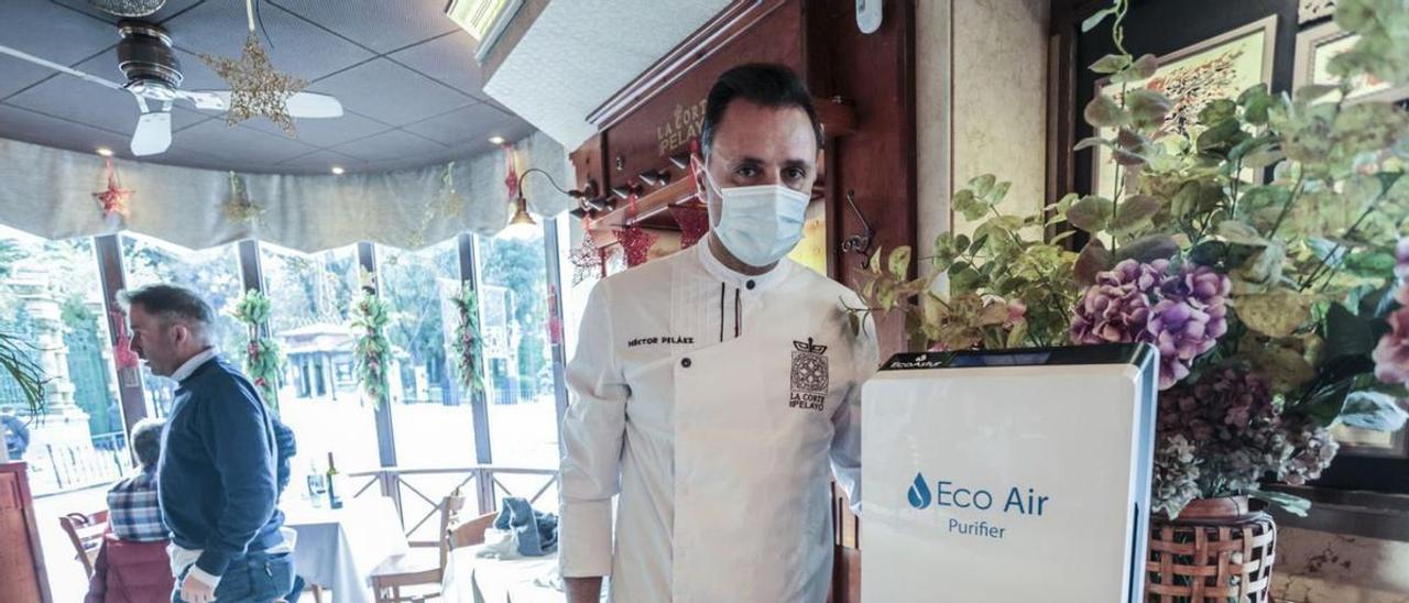 El camarero Héctor Peláez, ayer, con un medidor de CO2 en el restaurante La Corte de Pelayo (Oviedo). | Irma Collín