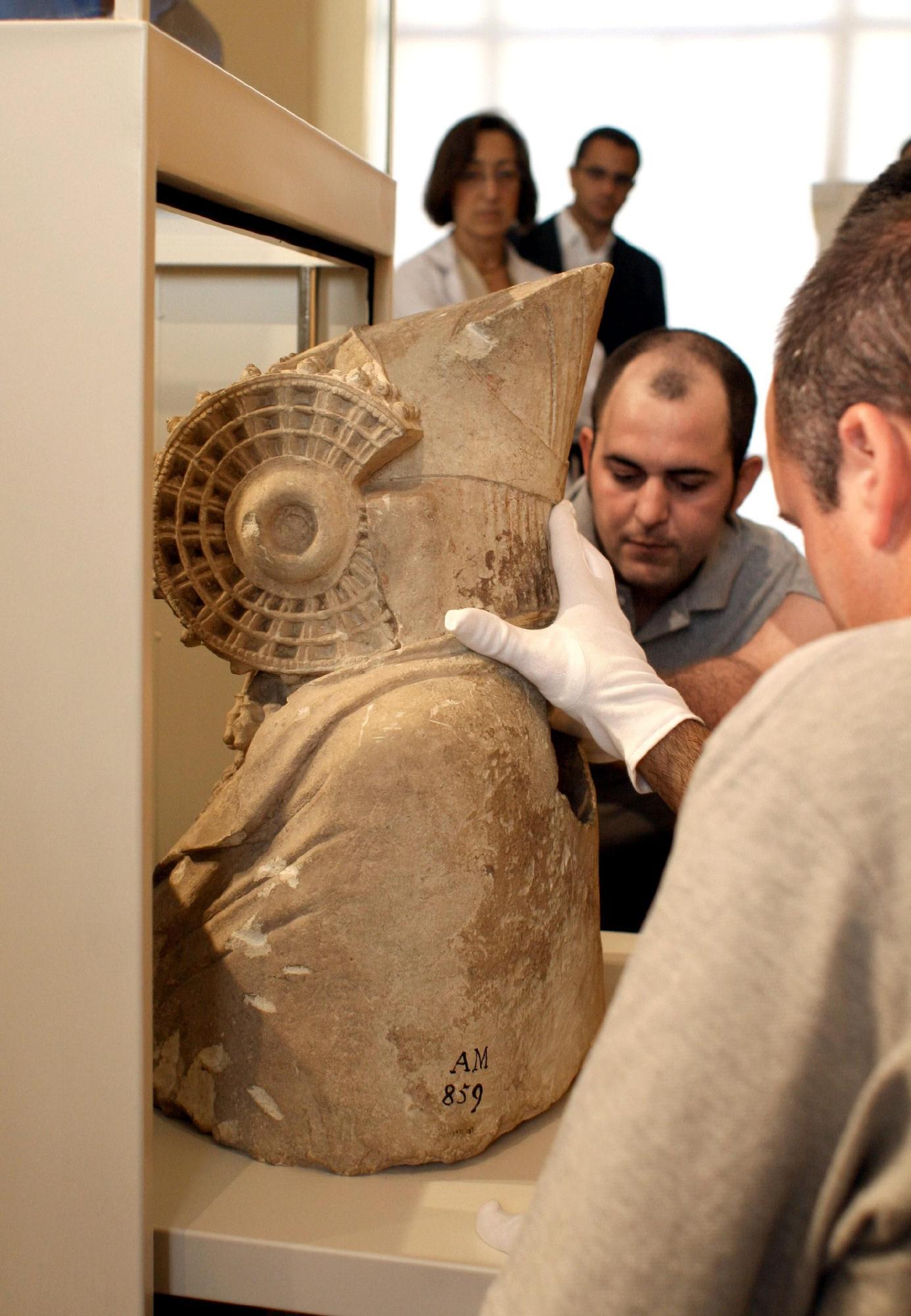 Varios funcionarios introducen la escultura en la caja en la que fue trasladada desde el Museo Arqueológico de Madrid al MAHE.