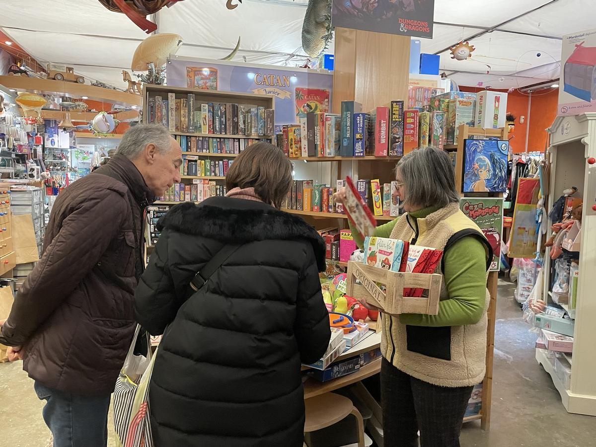 Montse Vilella i el seu marit a la botiga Zeppelin, assessorats per Maria Llapart