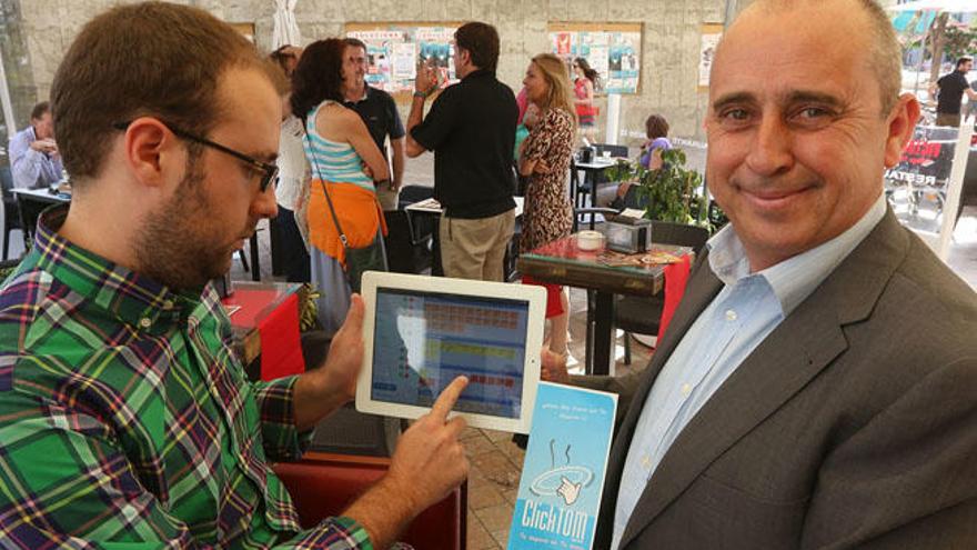 Federico Navas, a la derecha, muestra una tablet con el sistema informático de ClickTOM.