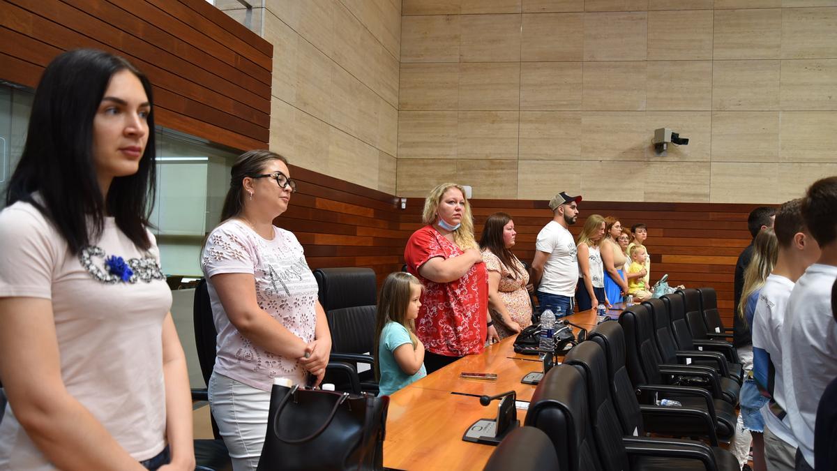 Refugiados ucranianos escuchando en pie el himno de su país, este sábado en la Asamblea.