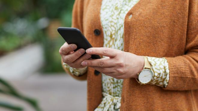 Una persona mayor utiliza un teléfono móvil