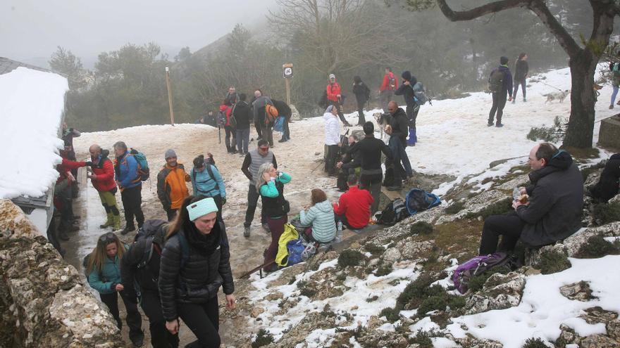 Turistas y senderistas  bloquean la carretera del Santuario de Agres en la Sierra de Mariola para disfrutar de la nieve