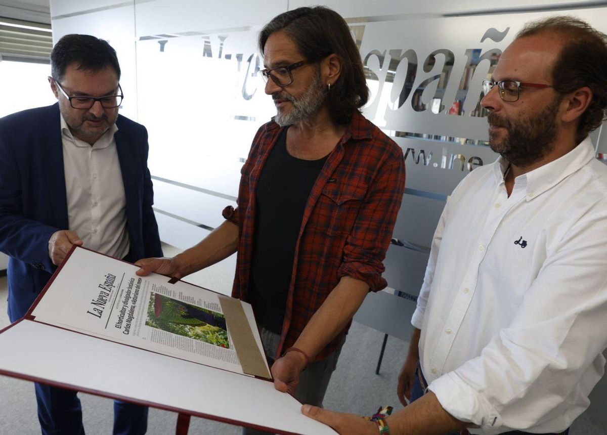 Carlos Magdalena mira una portada sobre su nombramiento como «Asturiano del mes», entre Gonzalo Martínez Peón, director de LA NUEVA ESPAÑA, a la izquierda, e Ignacio Peláez, delegado del periódico en Gijón.