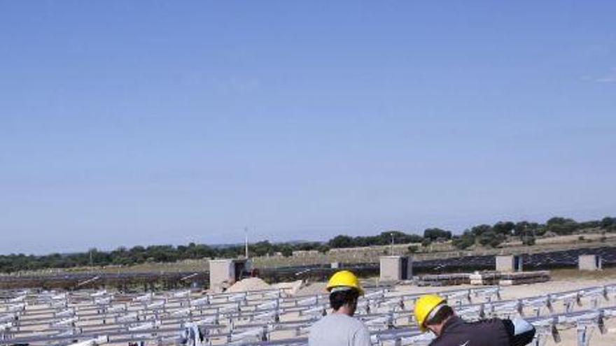 Dos operarios en una planta de energía fotovoltaica.