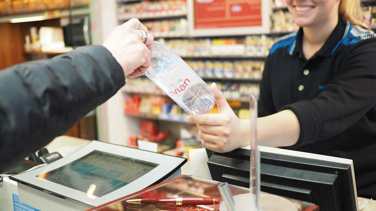 Un cliente entrega un envase al comercio para su reciclaje