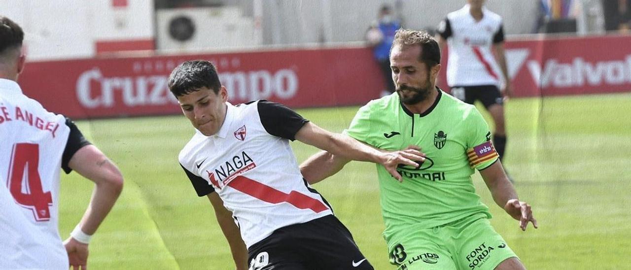 Canario intenta robar el balón a un futbolista del Sevilla Atlético.