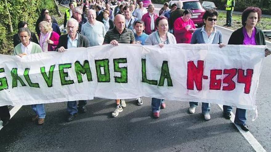 Arriba, la cabeza de la manifestación, que ocupaba medio carril de la carretera; a la derecha, los vecinos. / t. cascudo