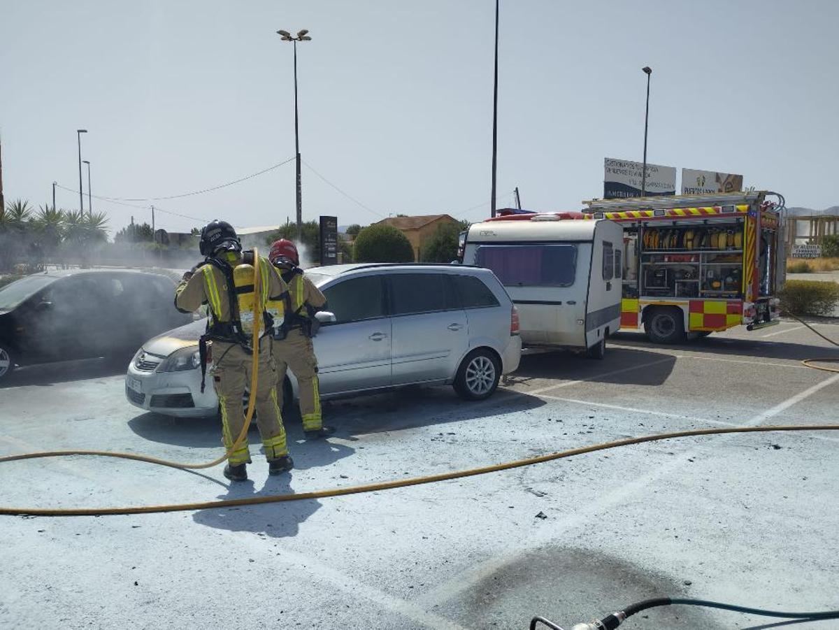 Los bomberos extinguen un incendio en un coche en el parking del Centro Comercial Almenara de Lorca.