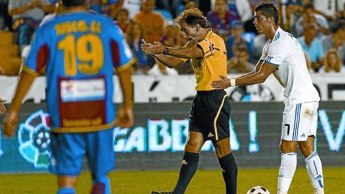 Cristiano Ronaldo agarra al árbitro Delgado Ferreiro antes de tirar una falta, ayer en el Ciutat de València.