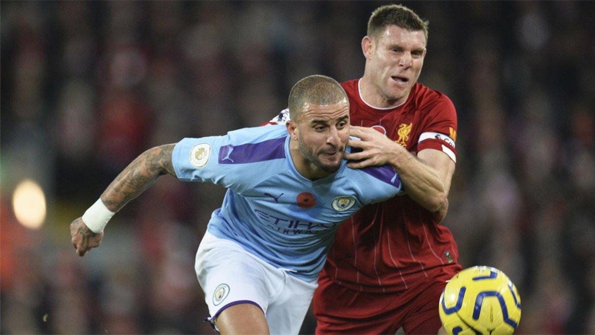 James Milner (derecha) y Kyle Walker disputan el balón durante el Liverpool-City de la Premier League 2019/20 disputado en Anfield