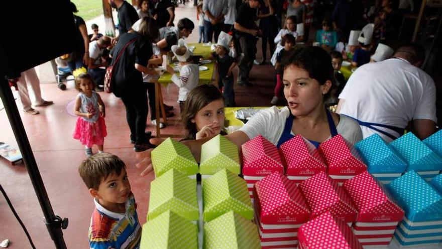 Una monitora explica a dos niños una tarea en el taller de quesos.