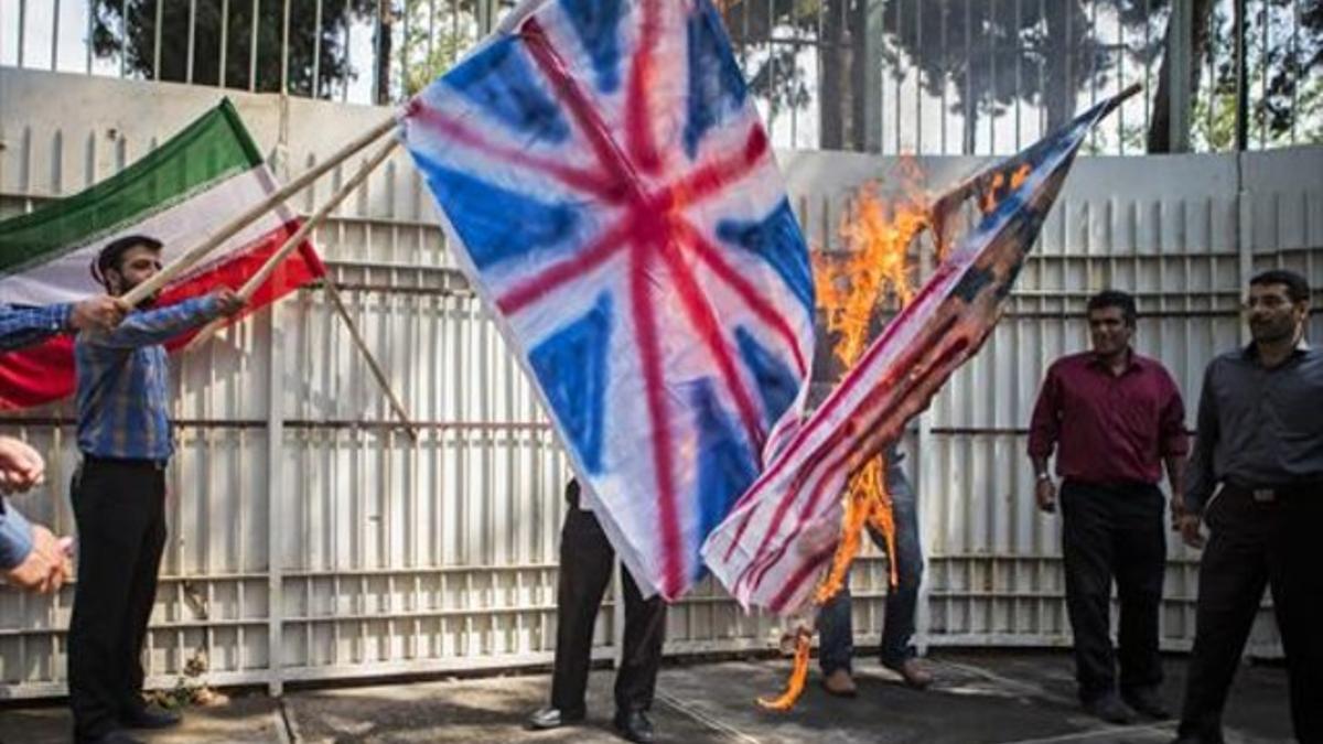 Estudiantes iranís queman banderas de EEUU y Gran Bretaña en Teherán, ayer.