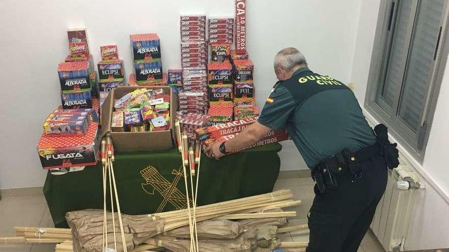 Un guardia civil, con el material pirotécnico ilegal incautado en Cangas. // Guardia Civil