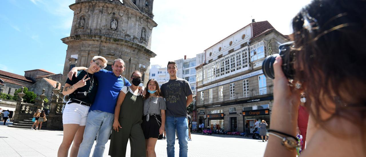 Un grupo de turistas se fotografía ante el santuario de A Peregrina