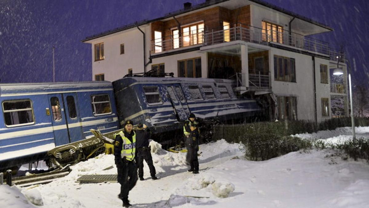 La policía inspecciona el lugar donde un tren ha colisionado con una vivienda tras descarrilar en Saltsjoebaden a las afueras de Estocolmo (Suecia).