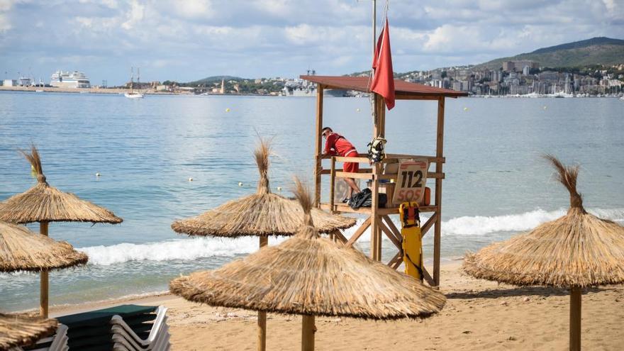 La bandera roja luce en una playa casi vacía en Can Pere Antoni.