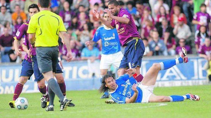 Curro, en el suelo, sigue la trayectoria del balón, que controla un jugador del Pontevedra tapado por el árbitro.