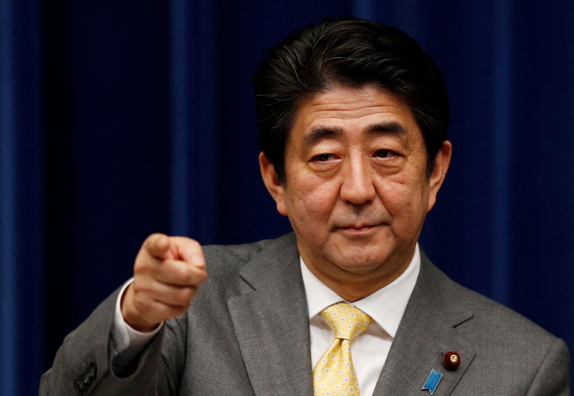 FILE PHOTO: Japan's Prime Minister Shinzo Abe points to a reporter during a news conference at his official residence in Tokyo