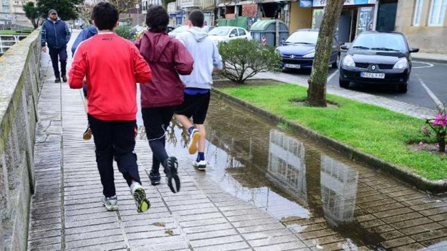 Vecinos paseando y haciendo deporte en la zona del paseo en la que se detecta el hundimiento.  // G.N.