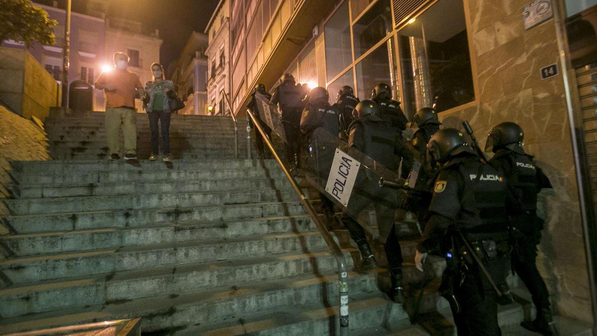 Los agentes antidisturbios toman posiciones y suben hacia la plaza de San Cristobal de Alicante para localizar a los vándalos dispersados.