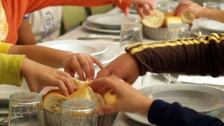 Varios niños cogen un trozo de pan en un comedor escolar. / c.c.p.
