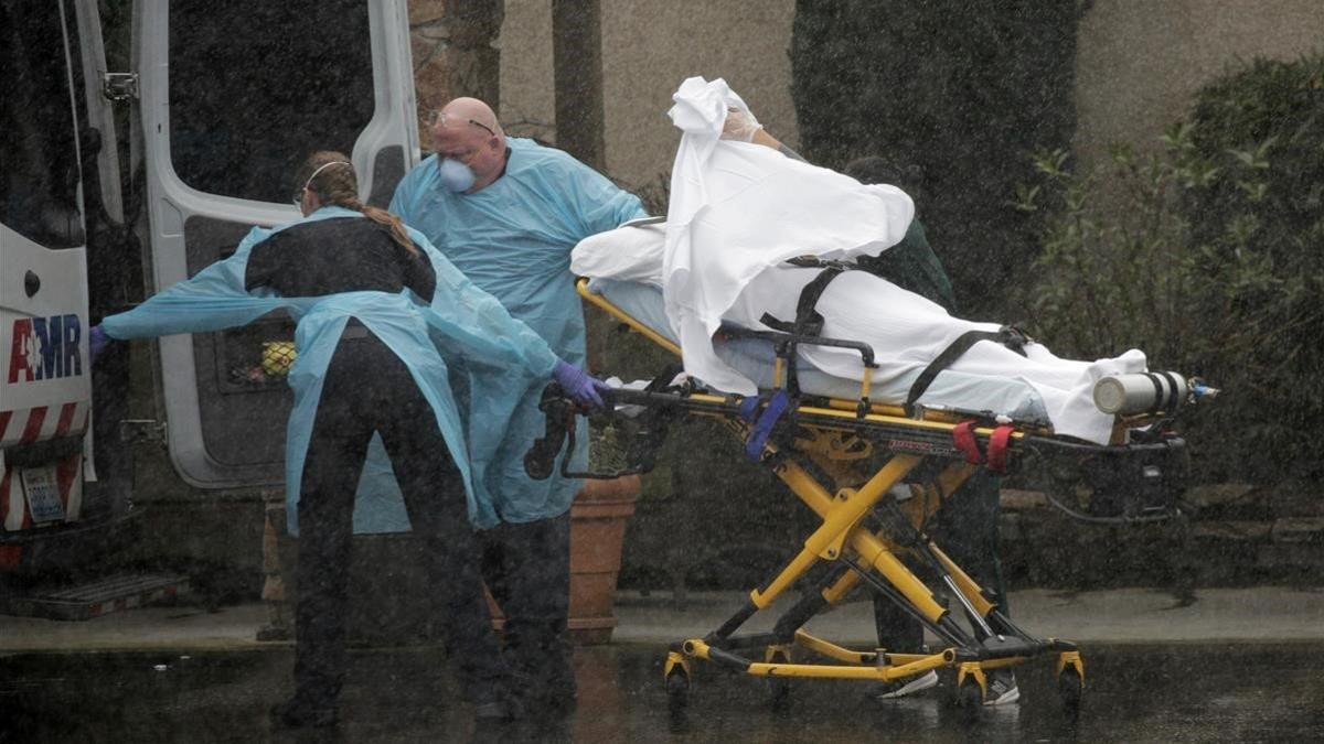 zentauroepp52679382 medics transport a patient through heavy rain into an ambula200308211344