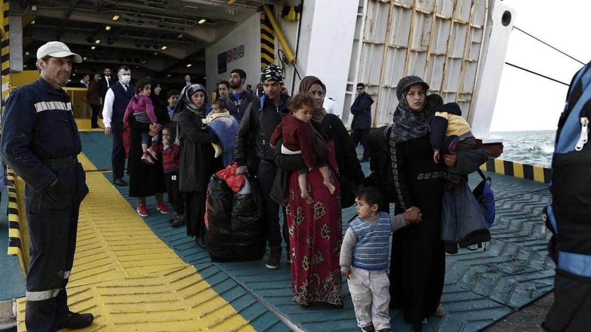 Refugiados y migrantes desembarcan del ferri 'Eleftherios Venizelos' a su llegada al puerto de Elefsina, a 20 kilómetros al noroeste de Atenas, procedentes de Lesbos, este lunes.