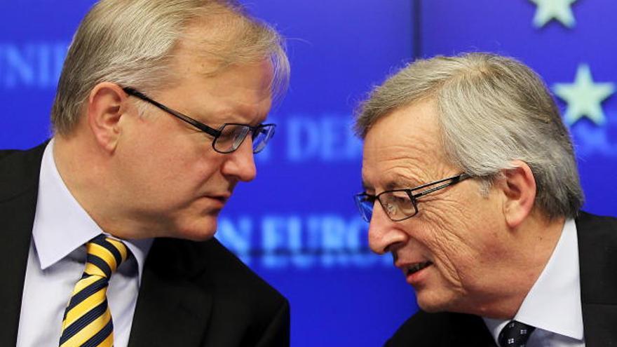 Olli Rehn, a la izquierda, charla con el presidente del Eurogrupo, Jean-Claude Juncker.