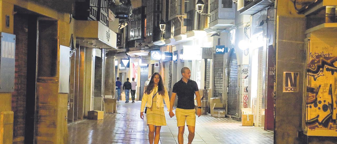 Una pareja pasea por el centro de Palma ayer pasadas las doce de la noche tras eliminar el Supremo el toque de queda.