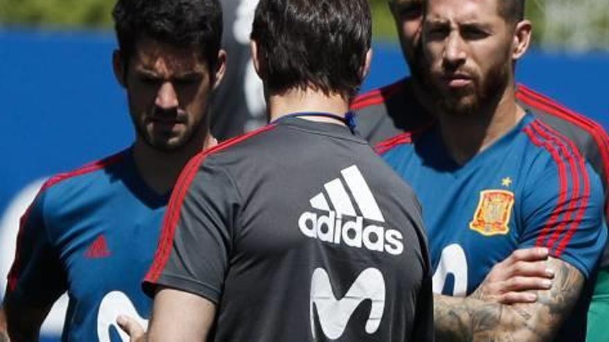 Lopetegui conversa con los madridistas Isco y Sergio Ramos durante el entrenamiento de ayer.