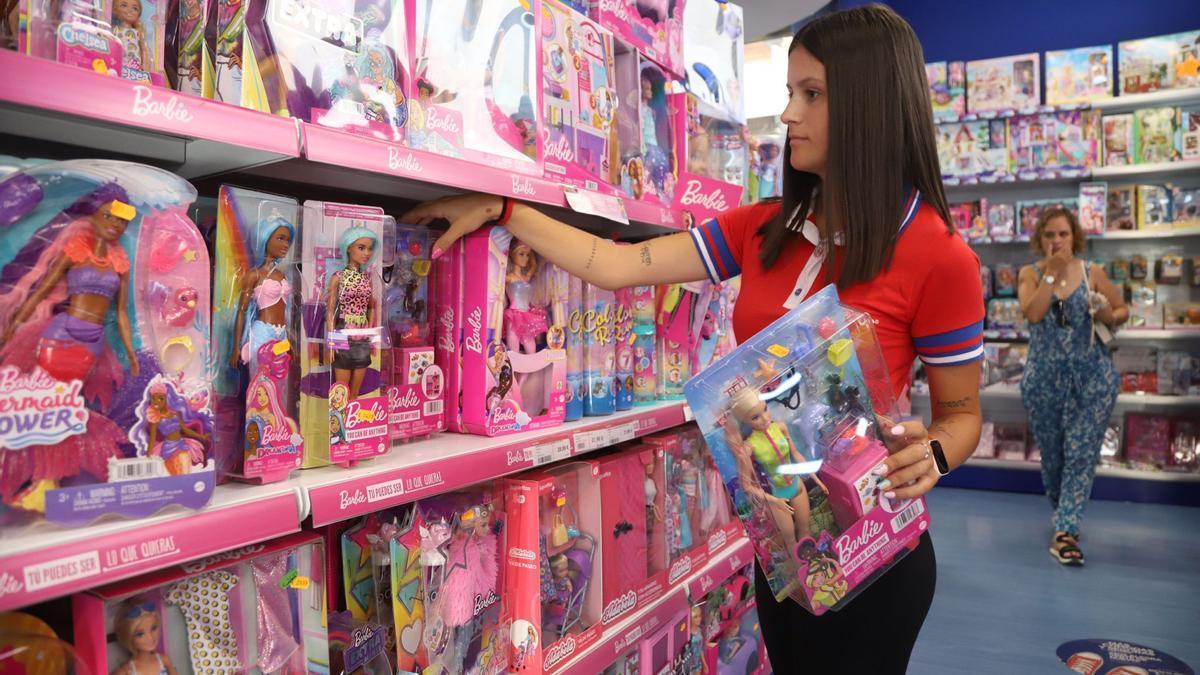 Una dependiente coloca artículos de Barbie en Juguettos.