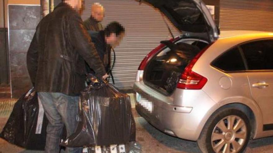 Policías nacionales cargan el material incautado en el registro de Petrer anoche