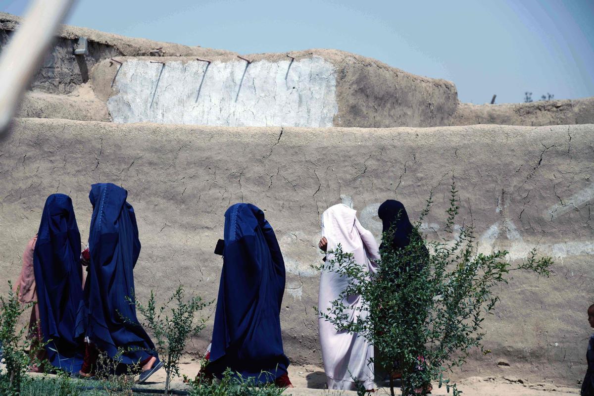 Afganas con burka trabajando en una fábrica de jabón y ropa en Kandahar