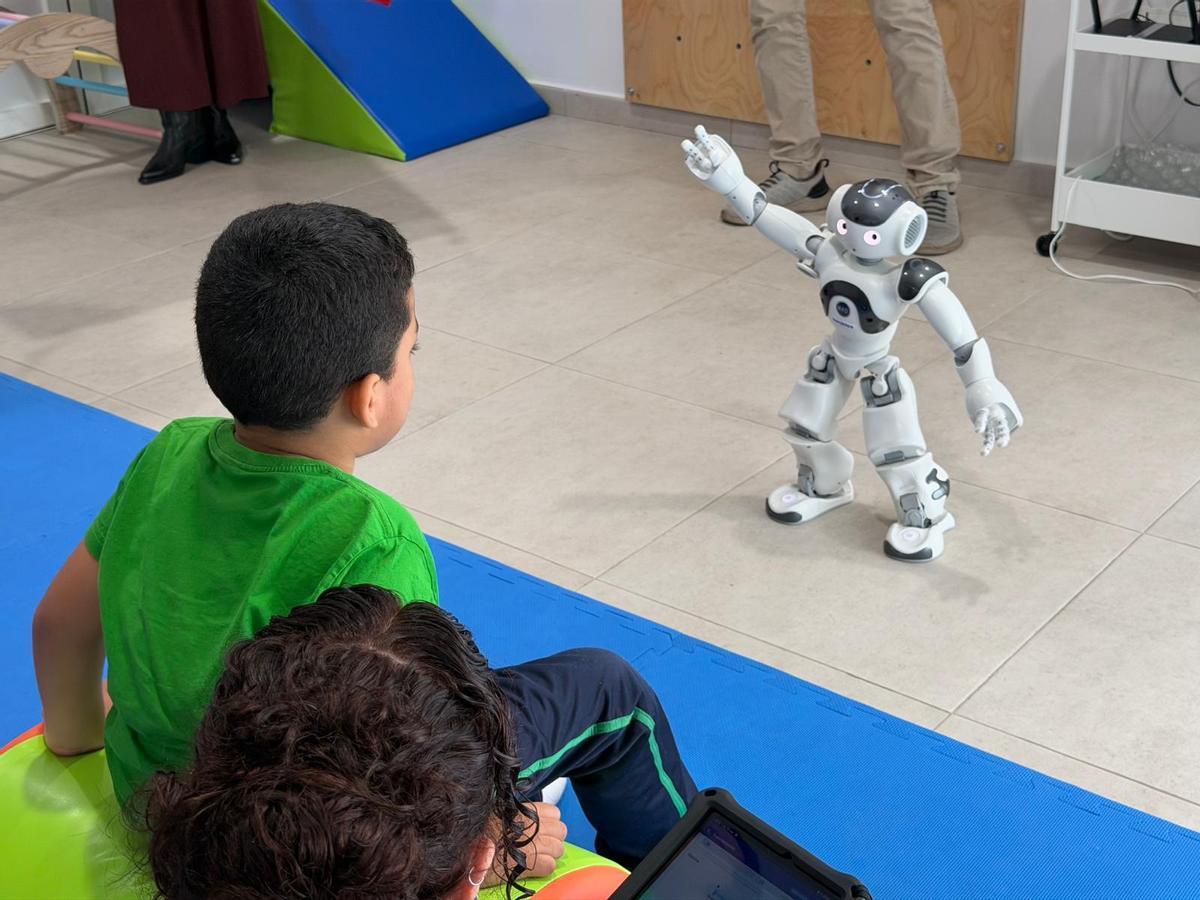 Liam Gamboa, de seis años, durante una sesión con ‘Juani’, el nuevo robot que CAIT de San Juan de Dios ha incorporado en sus terapias con niños.