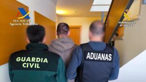 La policia amb un dels detinguts de la banda internacional de tràfic de drogues.