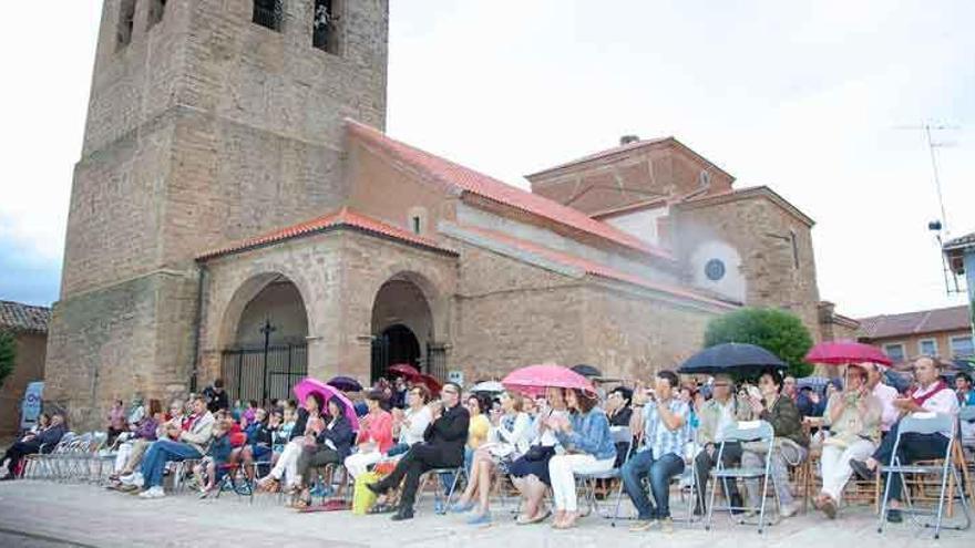 Vecinos de San Cristóbal asisten a una actuación musical en la plaza de la iglesia.