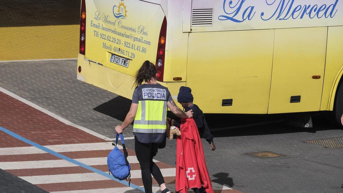 Un miembro de Cruz Roja acompaña a un menor llegado a las costas de Canarias.