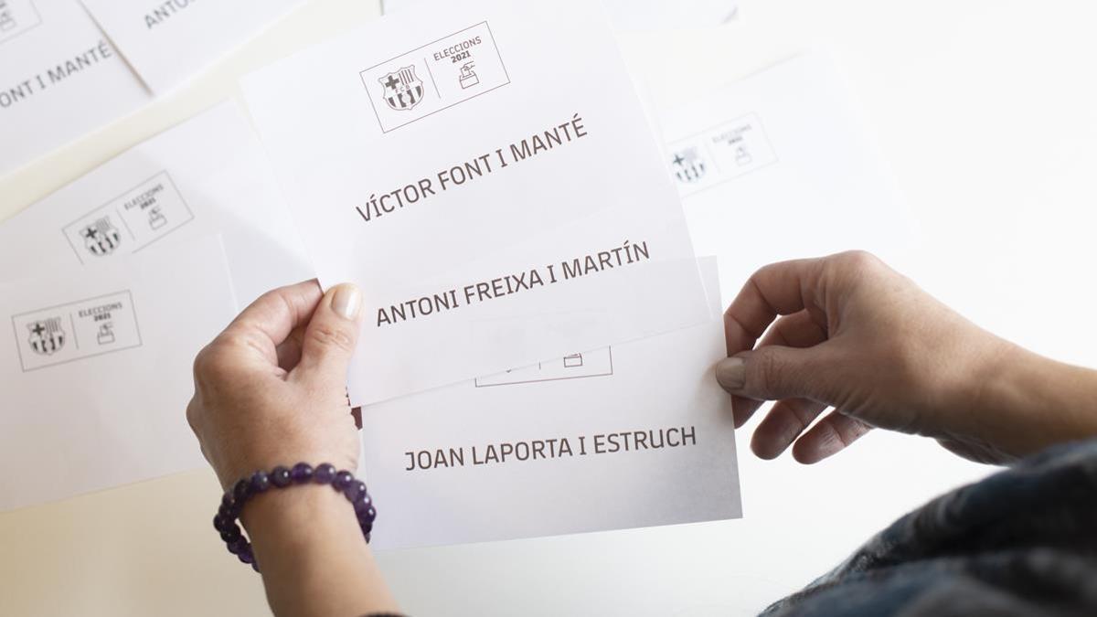 Una mujer sujeta las tres papeletas de votación en las elecciones del Barça-2021.