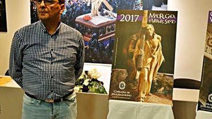 Un hombre junto a un cartel de una anterior edición.