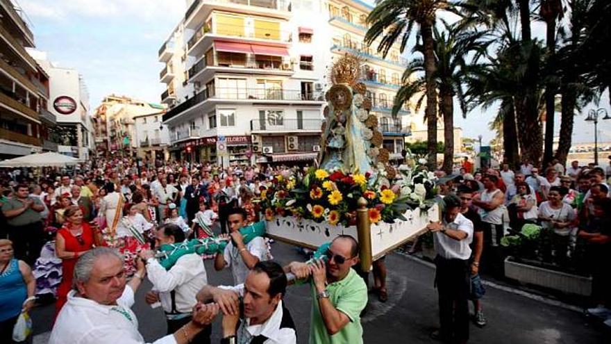 La imagen de la Virgen del Rocío, portada a hombros por miembros de la Casa de Andalucía, en un tramo de la romería que realizó ayer por las calles de Benidorm. Fotos de DAVID REVENGA