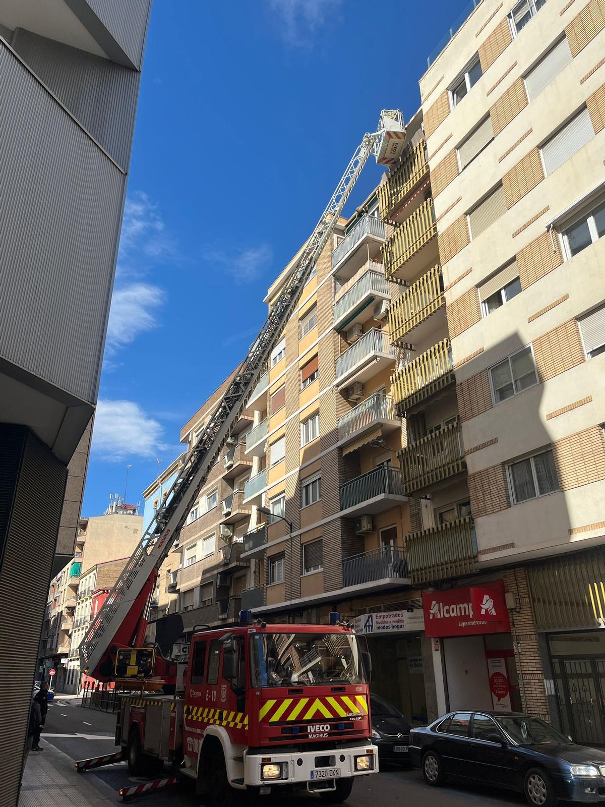 Los bomberos intervienen en la calle Carmen, este sábado, tras caer cascotes de una cornisa.