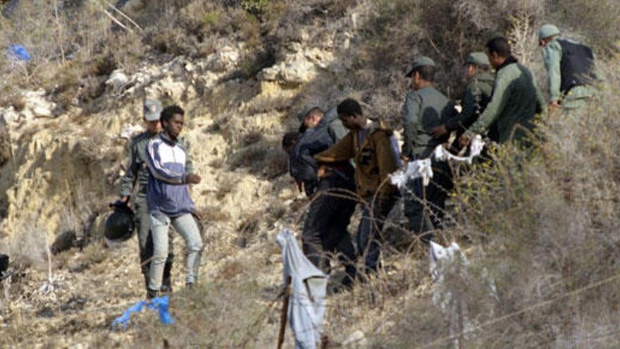 Vista de algunos inmigrantes, con las fuerzas de seguridad