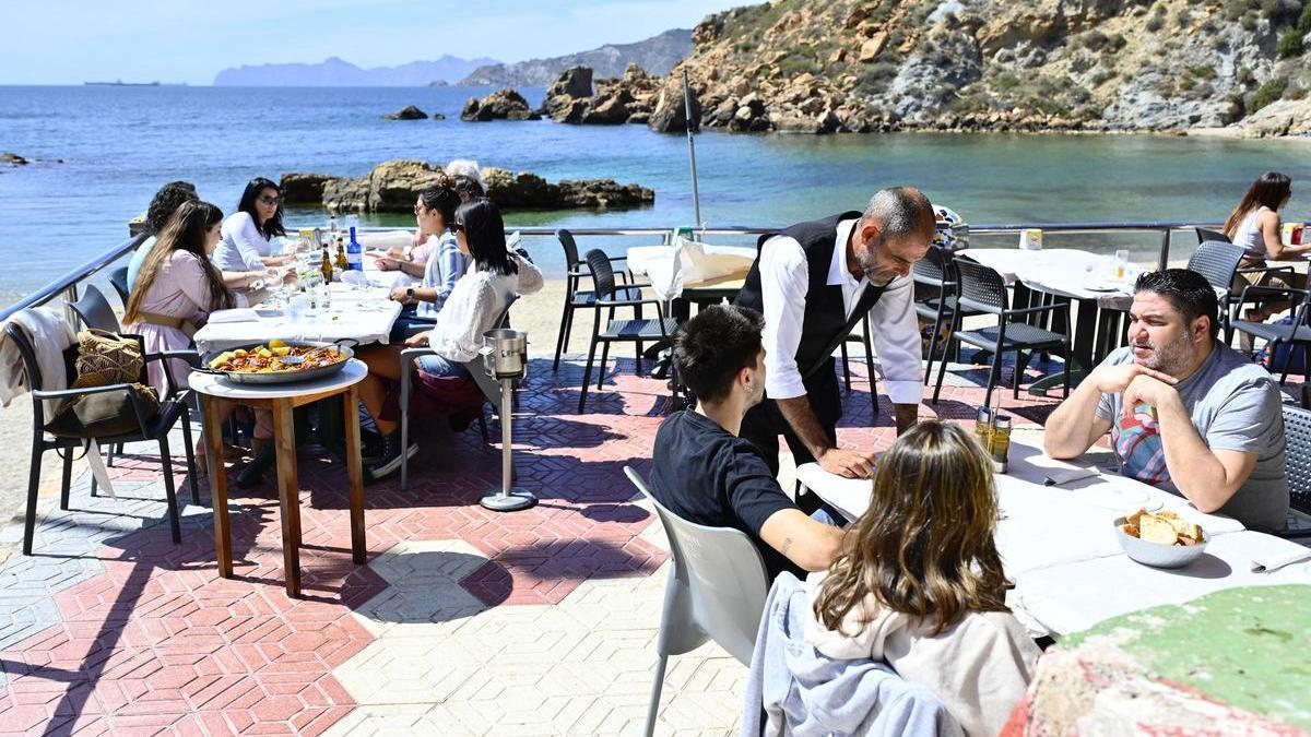 Un camarero atendiendo a clientes en el chiringuito de Cala Cortina, en Cartagena.
