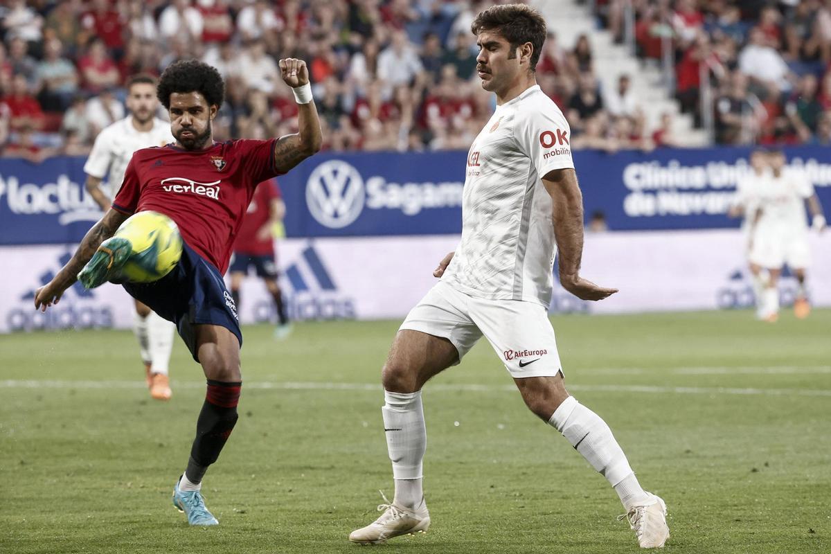 PAMPLONA, 22/05/2022.- El defensa de Osasuna Jonás Ramalho (i) despeja un balón junto a Abdón Prats, del RCD Mallorca, durante el partido de la jornada 38 de Liga en Primera División que Atlético Osasuna y RCD Mallorca disputan hoy domingo en el estadio de El Sadar, en Pamplona. EFE/Jesús Diges