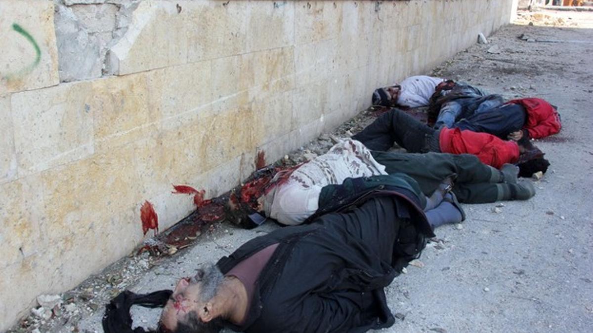 Hombres sirios ejecutados en los alrededores del cuartel general del ISIL en Alepo, ayer.