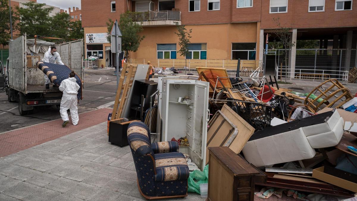 Dos trabajadores cargan en un camión las pertenencias de 62 familias okupas desalojadas de varios edificios de Alcobendas (Madrid), en junio del año pasado.