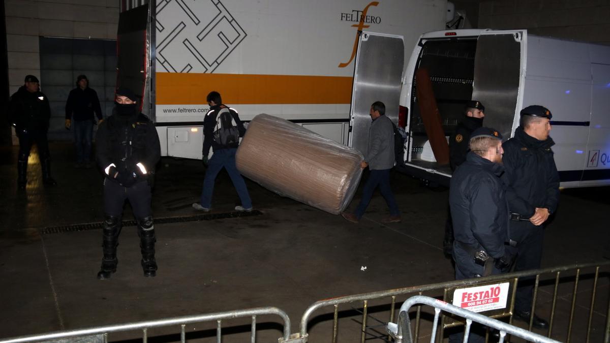 Trabajadores de la empresa encargada del traslado de las obras de arte descargan cajas ante el Museu de Lleida, esta madrugada.