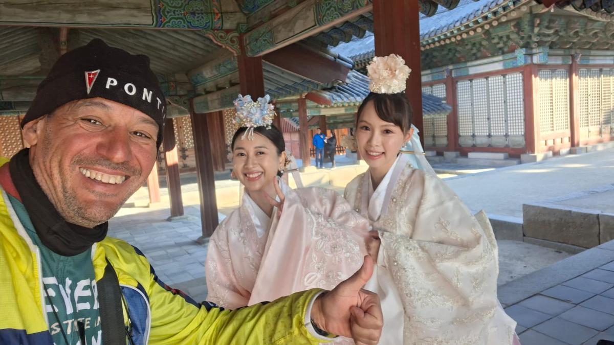 Pichi saluda junto a dos mujeres surcoreanas, a su llegada a Seúl.