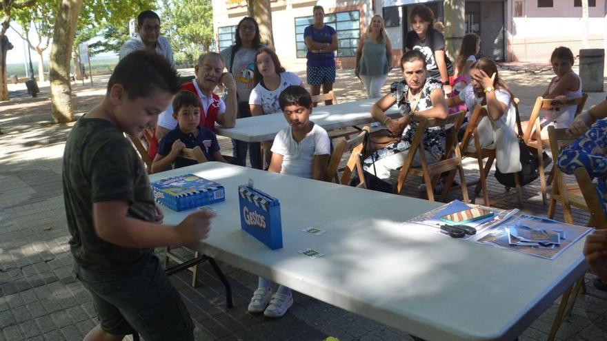 1.- Uno de los equipos intentando adivinar una palabra interpretando los gestos. 2.- Una técnico de Cruz Roja coordina la actividad. 3.- Los equipos atienden a las explicaciones del juego Gestos. 4.- Participantes en los juegos. 5.- Niños y mayores compartiendo una de las actividades lúdicas propuestas, en los Paseos de la Mota. | E. P.